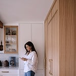 a woman standing in a kitchen looking at a phone - vegans oup brands