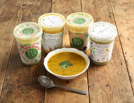 a group of containers of soup and a spoon
